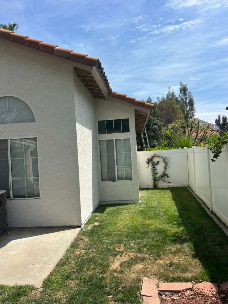 Side angle of completed exterior repaint with fresh fascia — Riverside, CA