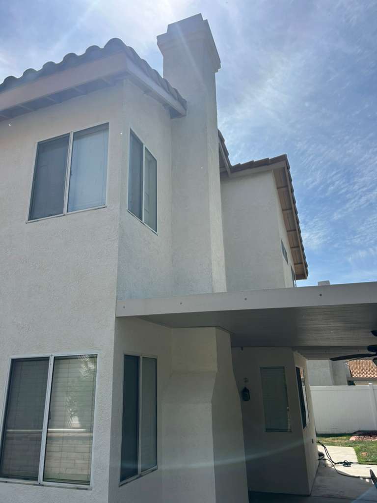 Fresh fascia, eaves, and chimney trim detail on residential exterior — Riverside, CA