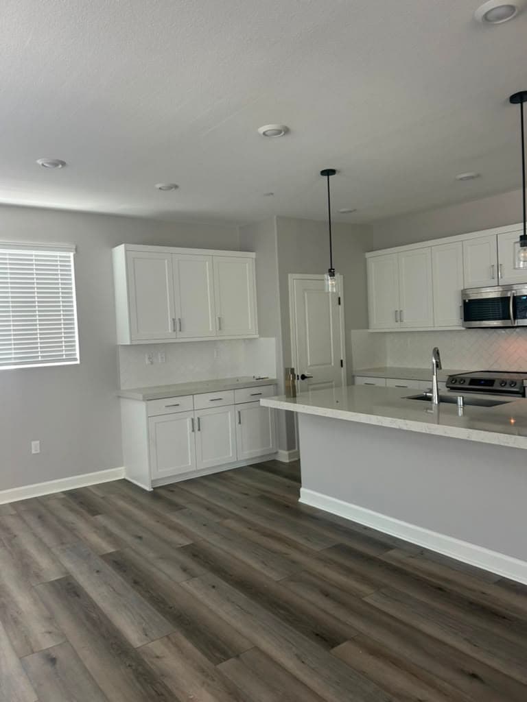 Recently repainted open-concept kitchen with crisp white cabinets and clean walls — Riverside, CA